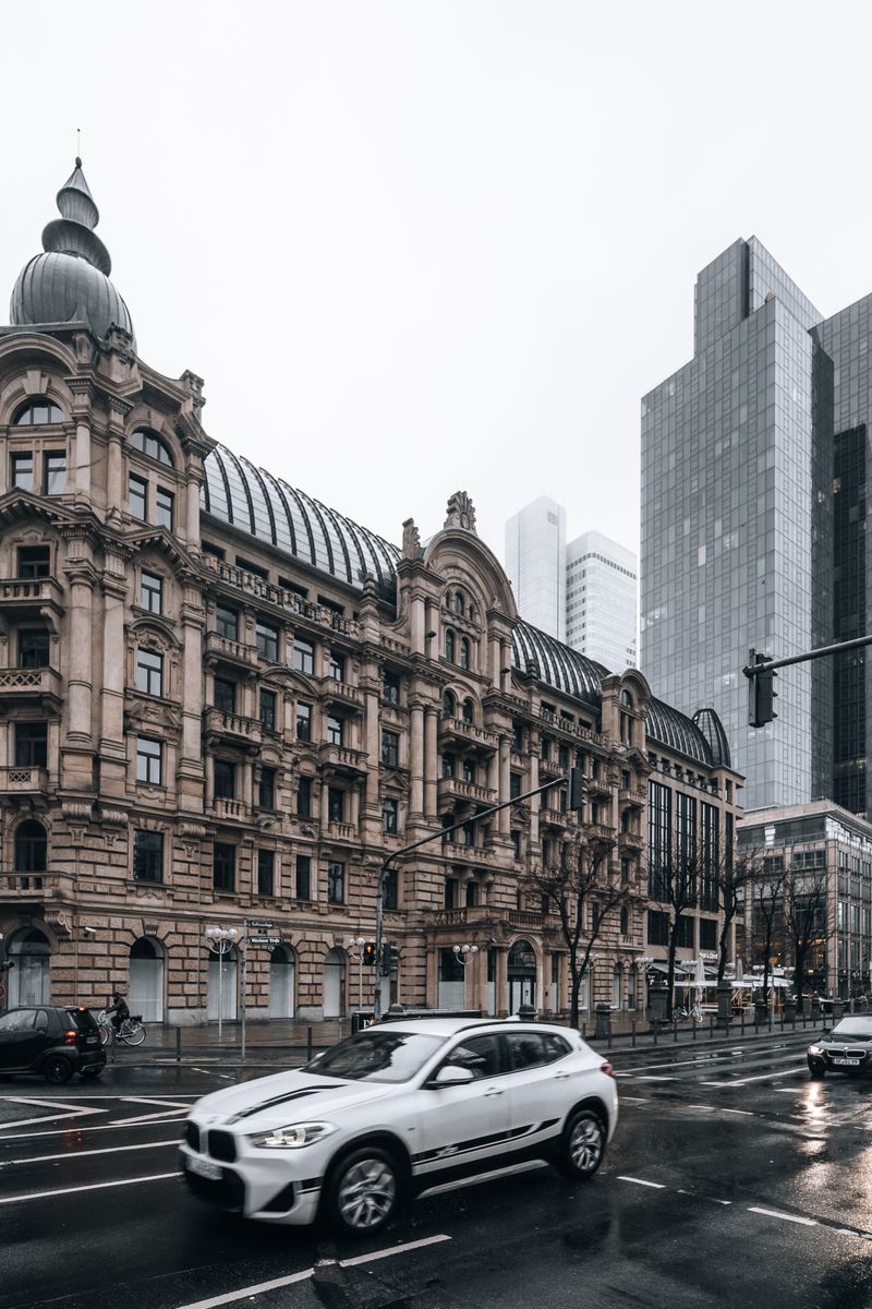 A striking city intersection with historic and modern buildings under a cloudy sky.