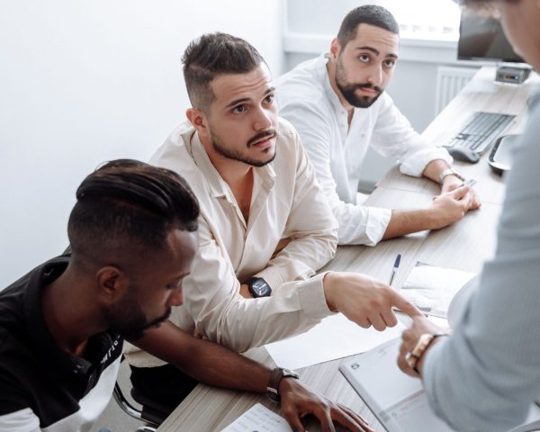 Multicultural team engaged in discussion at a meeting, showcasing teamwork and diversity.